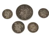 six different types of silver coins on a white surface