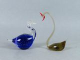 two glass birds sitting next to each other on a table