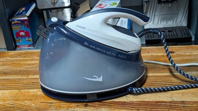 a blue and white steam iron sitting on a wooden table