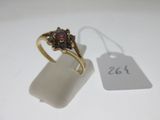 an image of a gold ring with a garnett and a price tag