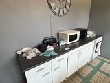 une horloge accrochée au mur au-dessus d'un plan de travail dans une cuisine