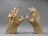 pair of hands made out of clay on a gray background