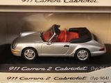 a silver toy car with a red top in a display case