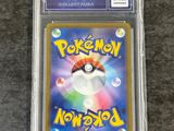 a pokemon card in a clear plastic case on a table