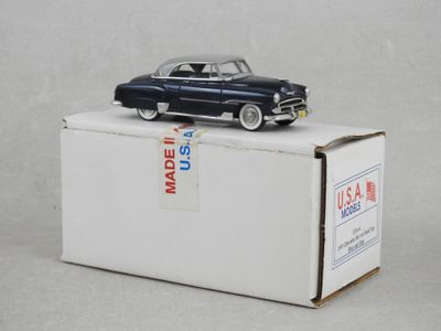 une petite voiture jouet posée sur une boîte