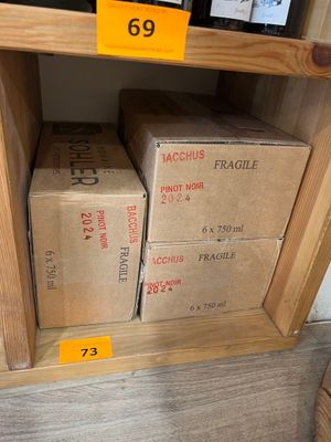 de nombreuses caisses de vin sur une étagère dans un magasin