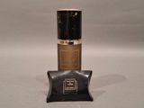 an image of a bottle of perfume sitting on top of a black bag