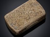 a silver box with a design of flowers and leaves on it