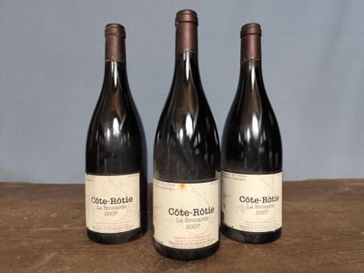 three bottles of wine sitting on top of a wooden table