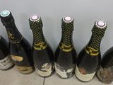 six bottles of wine lined up in a row on a tiled floor