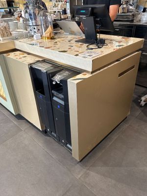 un homme debout devant un comptoir, avec un ordinateur portable devant lui