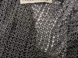 a close up of a black and white sweater with a tag on it