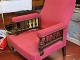 une chaise rose qui se trouve dans une pièce