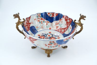 a blue and red bowl sitting on a gold stand