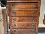 a tall wooden chest of drawers in a store