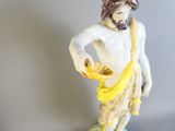 une figurine représentant un homme tenant une banane à la main