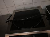 a stove top with a black burner on it in a kitchen