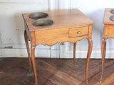 two wooden tables with bowls on them in a room