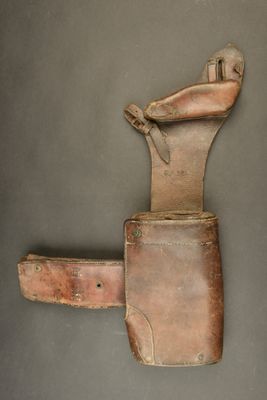 an old leather tool case with a knife in it on a gray surface