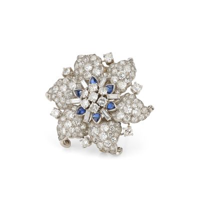 un gros plan sur une bague ornée d'une fleur en diamants et saphirs