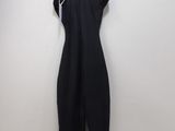 a black dress hanging on a hanger against a white wall