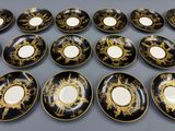 douze assiettes noires et dorées ornées de motifs dorés