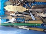 many different types of knives and spoons in a blue container