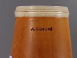 a close up of a wooden vase with a name on it