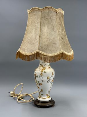 une photo d'une lampe de table avec un abat-jour blanc et doré