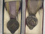 three medals are in a box on a white surface