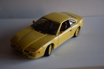 une petite voiture jaune posée sur une surface blanche