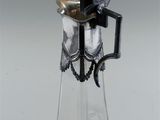 a clear glass bottle with a silver lid and a black handle