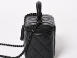 a black quilted bag with a chain hanging from it