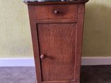 a small cabinet with a marble top on the floor