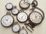 many different types of pocket watches sitting on a table