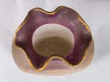 a purple and gold vase sitting on a white surface