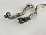 pair of silver plated fork and spoons on a white surface
