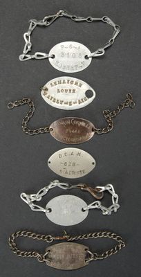 plusieurs types de bracelets différents, portant des noms, sur un fond noir