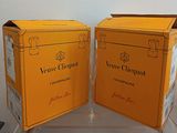 two boxes of champagne sitting on a table next to each other