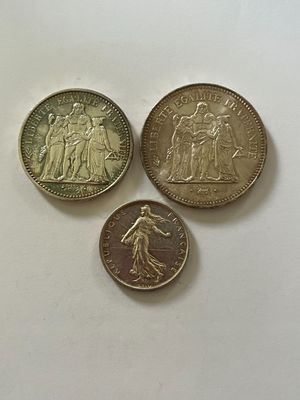 trois pièces de monnaie britanniques différentes posées sur une surface blanche