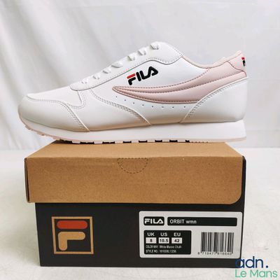 des chaussures Fila dans une boîte posée sur une table, sur fond blanc