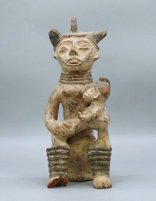 an old figurine of a man holding a baby