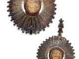 une paire de motifs en forme de rayons de soleil en laiton antique sur fond blanc