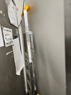 a ladder that is leaning against a wall with papers on it