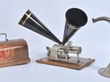 un téléphone à cornet argenté et noir posé à côté d'un coffret en bois