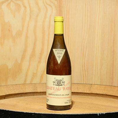 une bouteille de vin posée sur un tonneau en bois