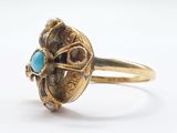 an image of a gold ring with a turquoise stone in the center