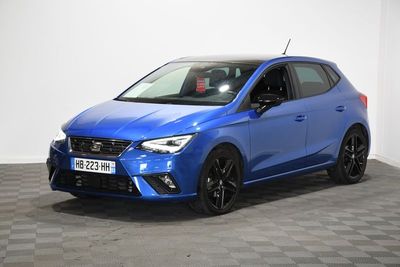 Une Seat León bleue est garée sur un sol à damier