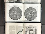 three open books on a table with drawings of buildings on them
