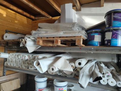 several cans of paint on a shelf in a garage